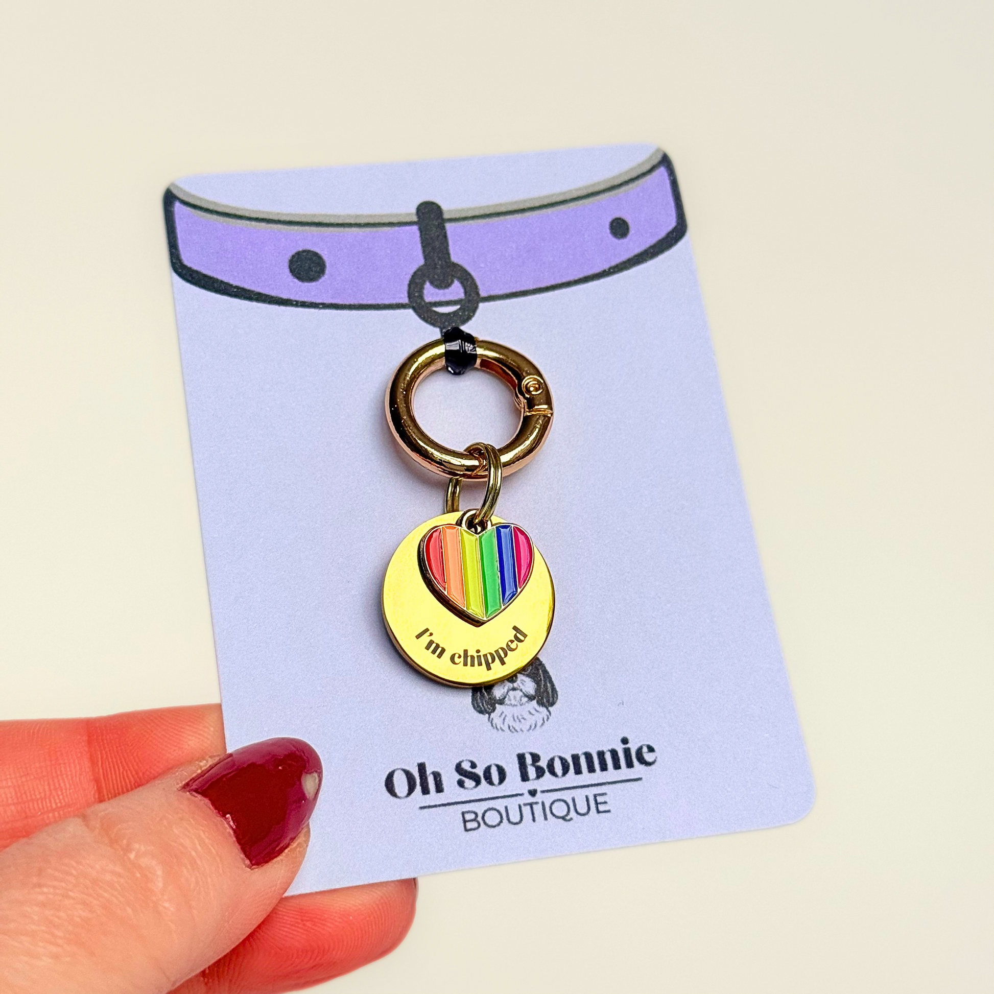 Gold brass rainbow striped heart dog collar ID tag, Enamel charm with dog name and address details. easily clips onto collar or harness. Pictured on the display card.