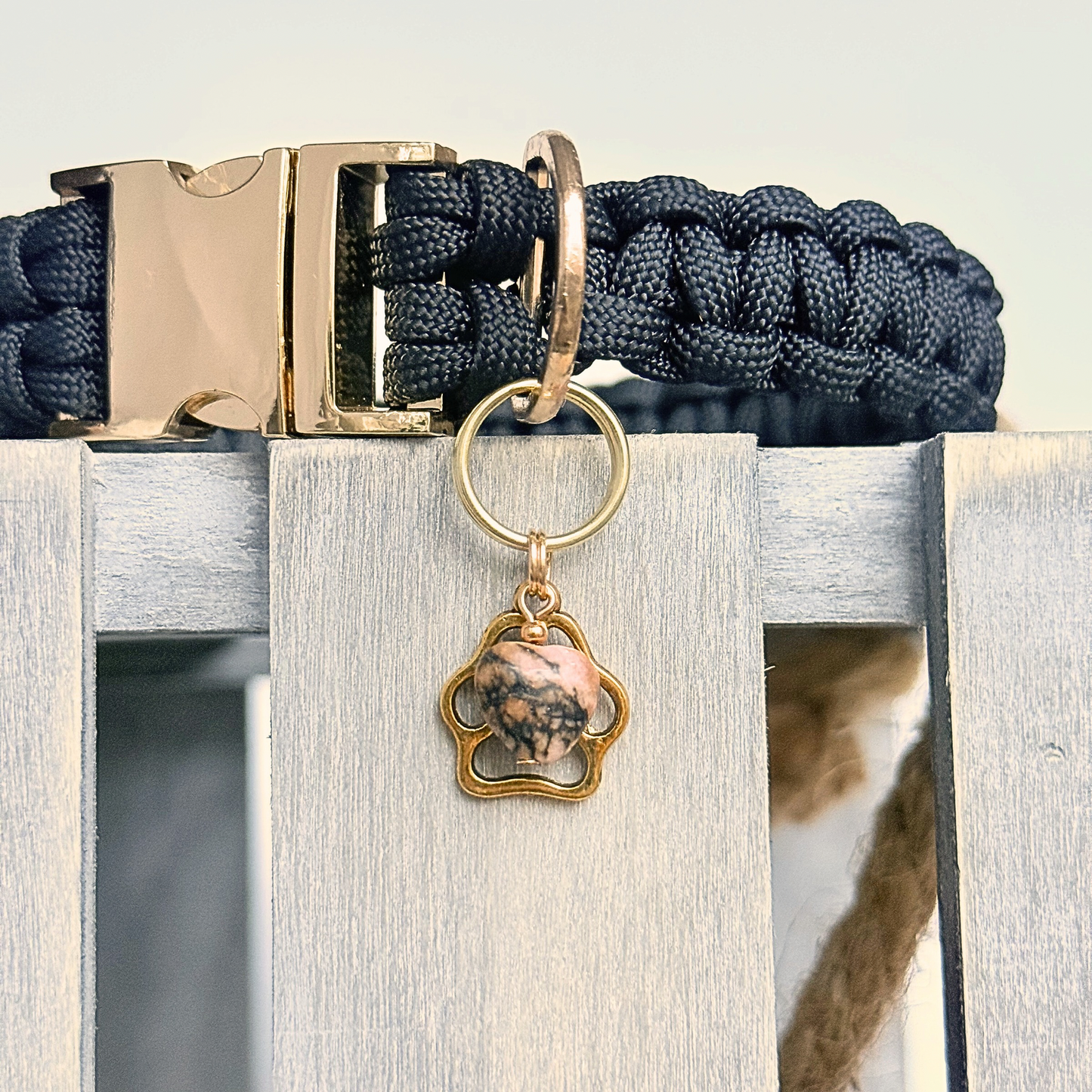 Crystal for dogs pet collar charm featuring a 10mm rhodonite heart shaped bead and a brass gold coloured paw print tag. 
