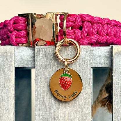 Gold red strawberry dog collar ID tag, Enamel fruit charm with dog name and address details. easily clips onto collar or harness. Attached to a pink paracord dog collar.