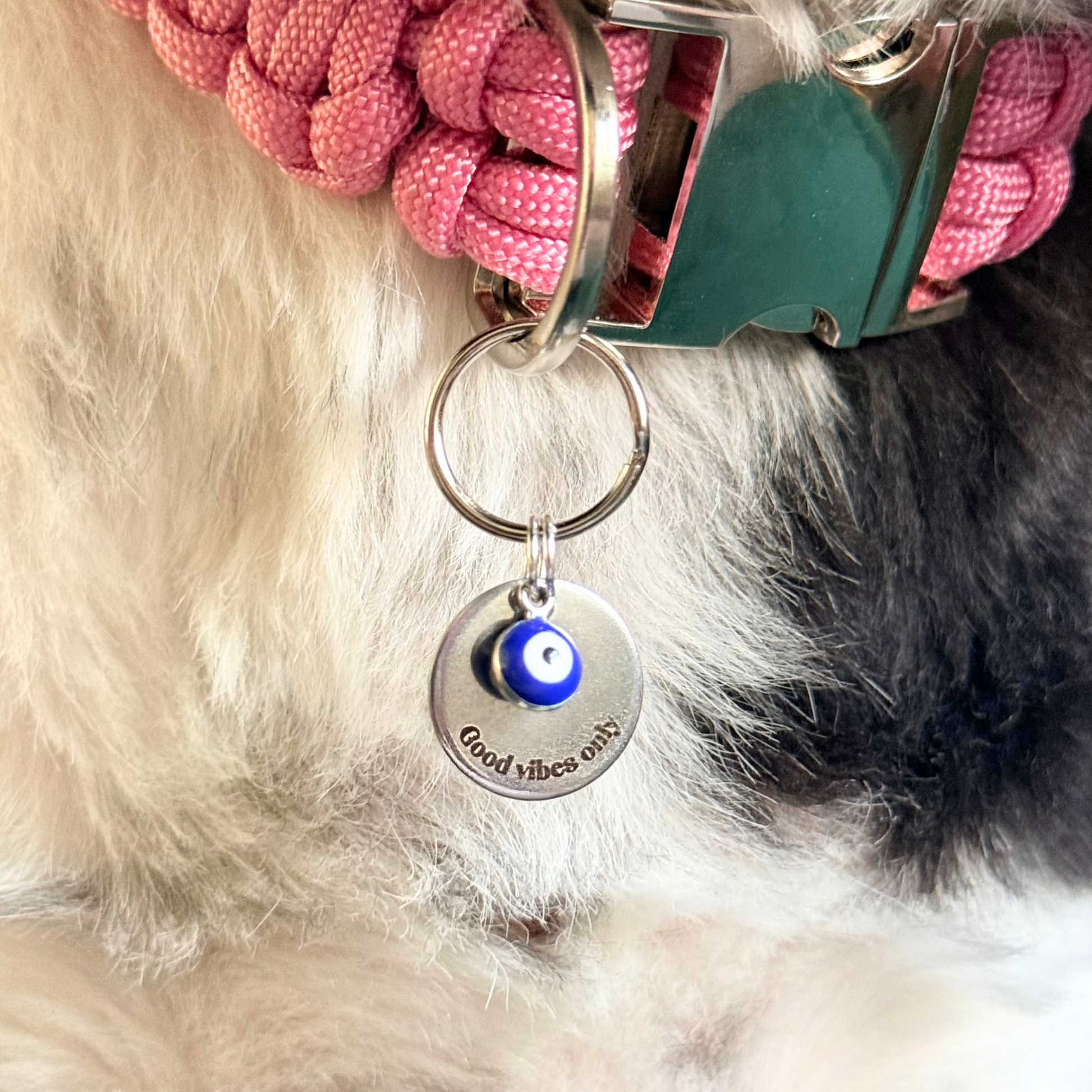 Silver plated brass and stainless steel 15mm dog collar charm with ID tag. Personalised custom identification tag with a small, blue Turkish Evil Eye charm, on a 15mm silver split ring. Engraved with the words ‘Good vibes only’ on the front. Pictured close up.