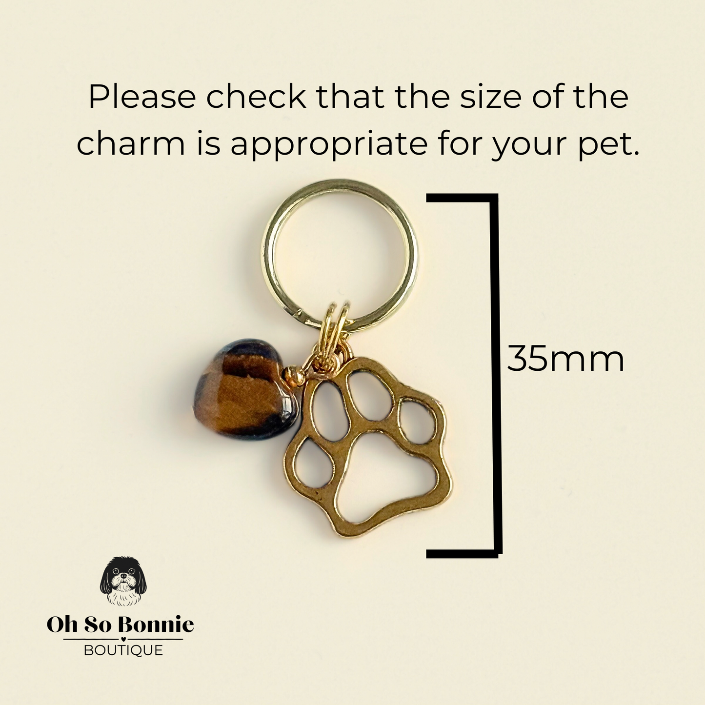 Crystal for dogs pet collar charm featuring a 10mm tigers eye heart shaped bead and a brass gold coloured paw print tag. Pictured showing dimensions.