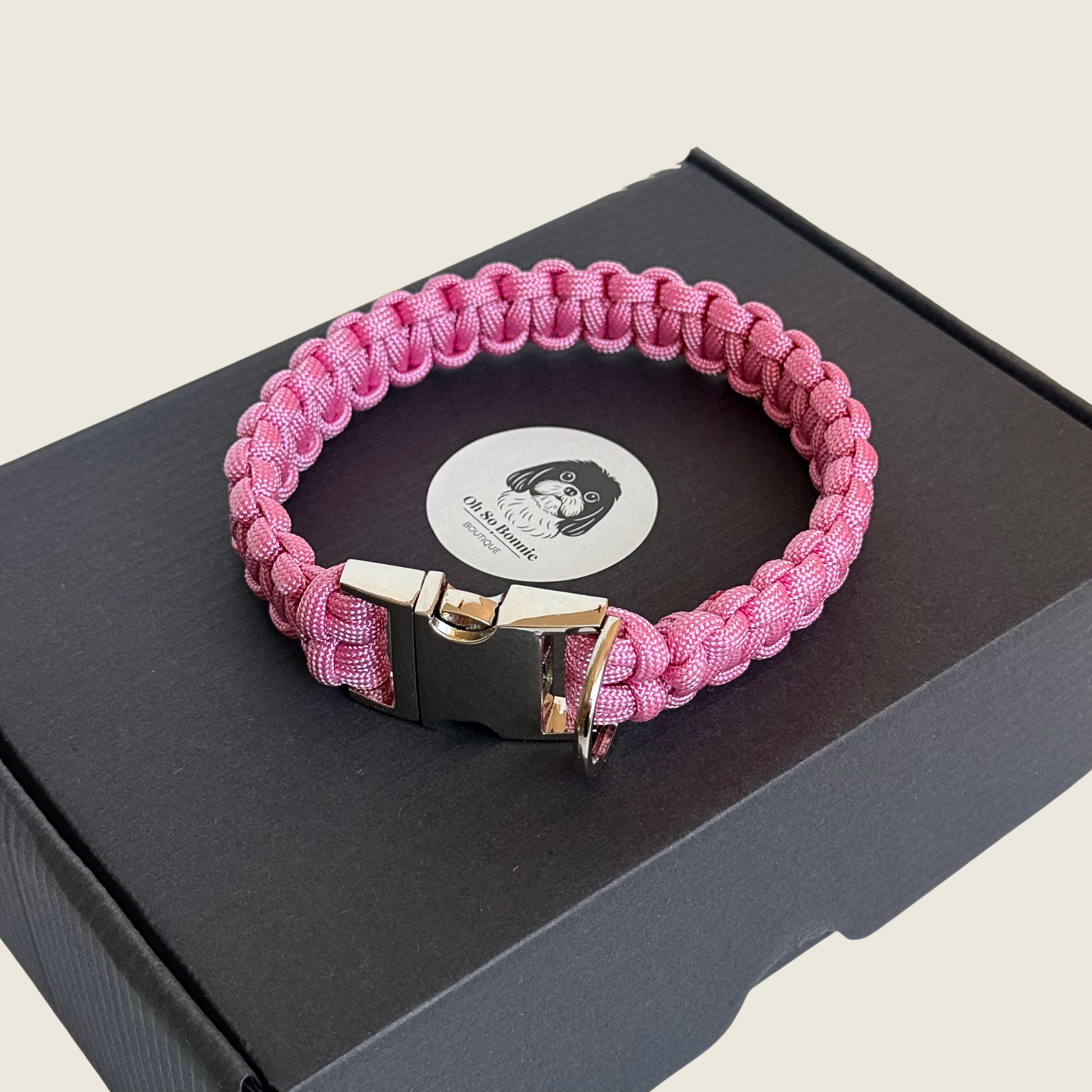 ‘Lavender pink’ handmade paracord dog collar with silver coloured buckle clasp. Custom made to your required size. Braided macrame style pet neckwear. Pictured on the top of the gift box.