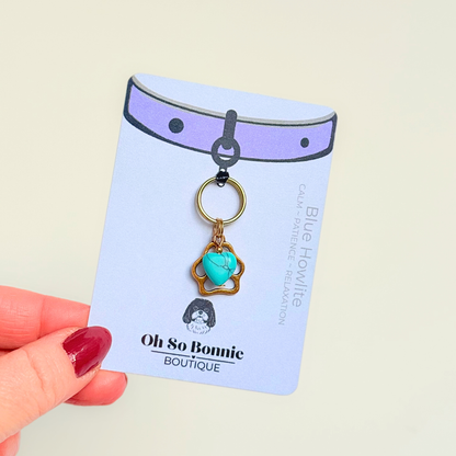 Crystal for dogs pet collar charm featuring a 10mm turquoise blue howlite heart shaped bead and a brass gold coloured paw print tag. Pictured on the display card.