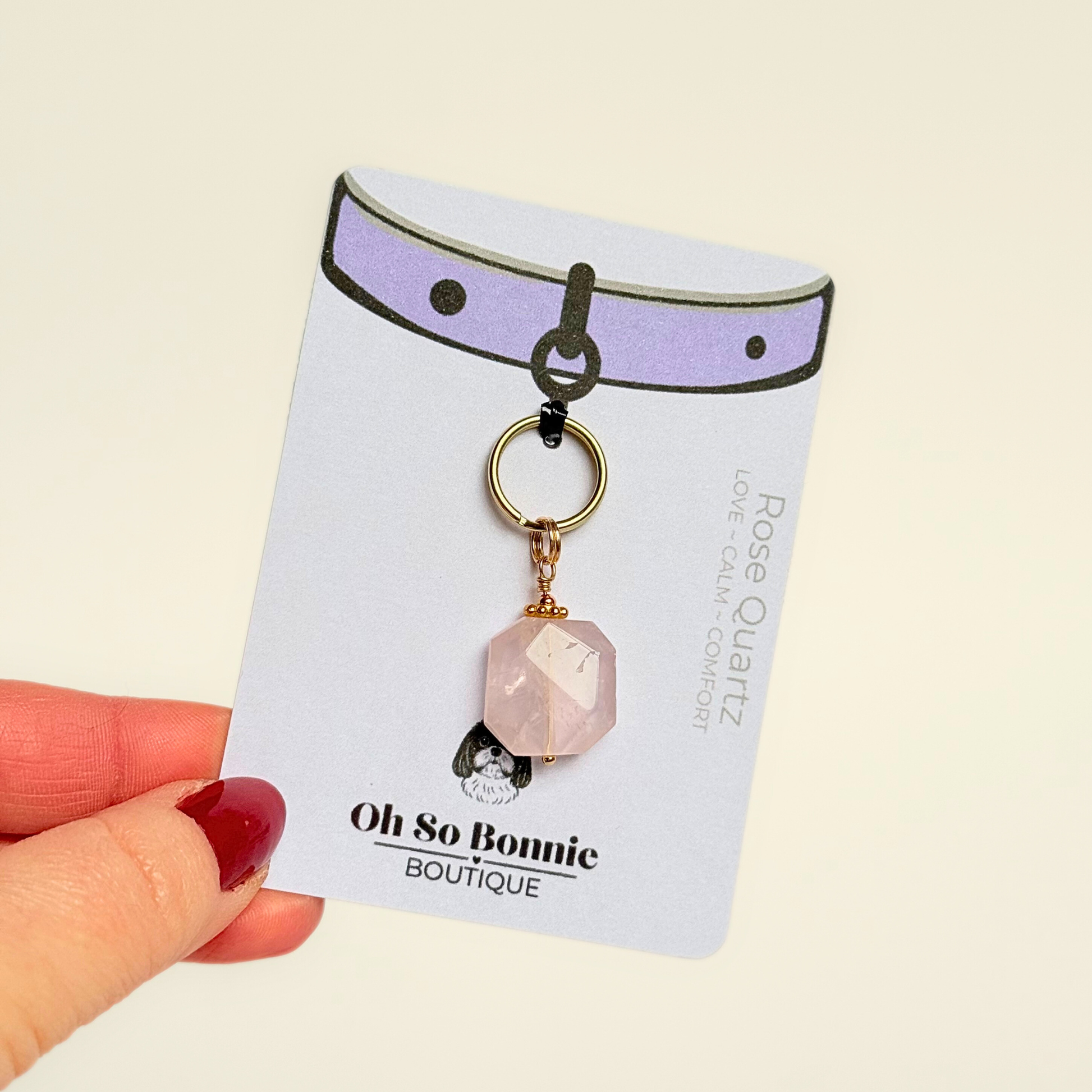 Handmade dog collar charm featuring a 17mm pink rose quartz natural gemstone faceted square crystal bead. Hung on a gold plated brass split ring with a daisy gold spacer bead that attaches onto your pet collar. Rose quartz can help pets with love, comfort and calming. Pictured on the display card.