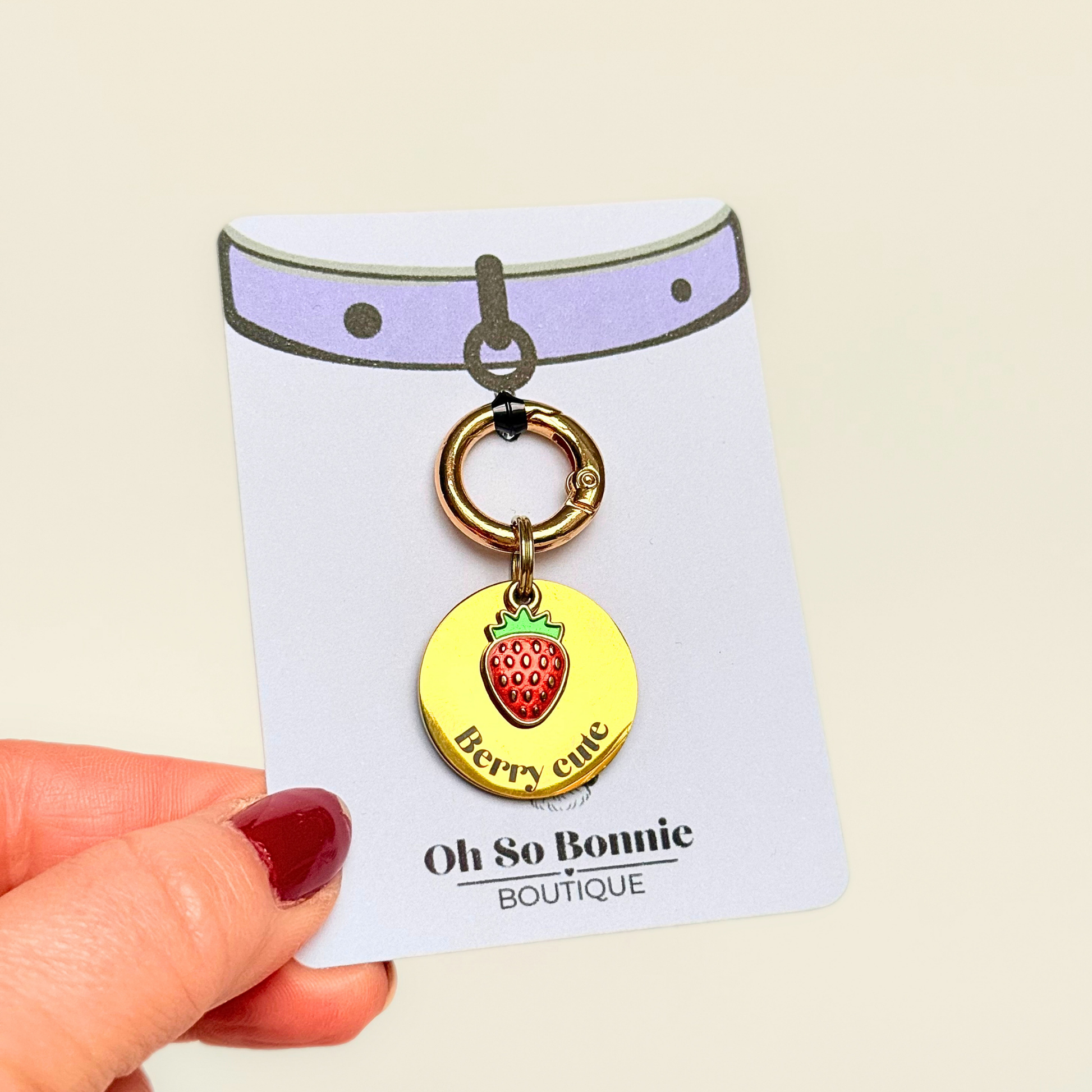 Gold red strawberry dog collar ID tag, Enamel fruit charm with dog name and address details. easily clips onto collar or harness. Pictured on the display card.