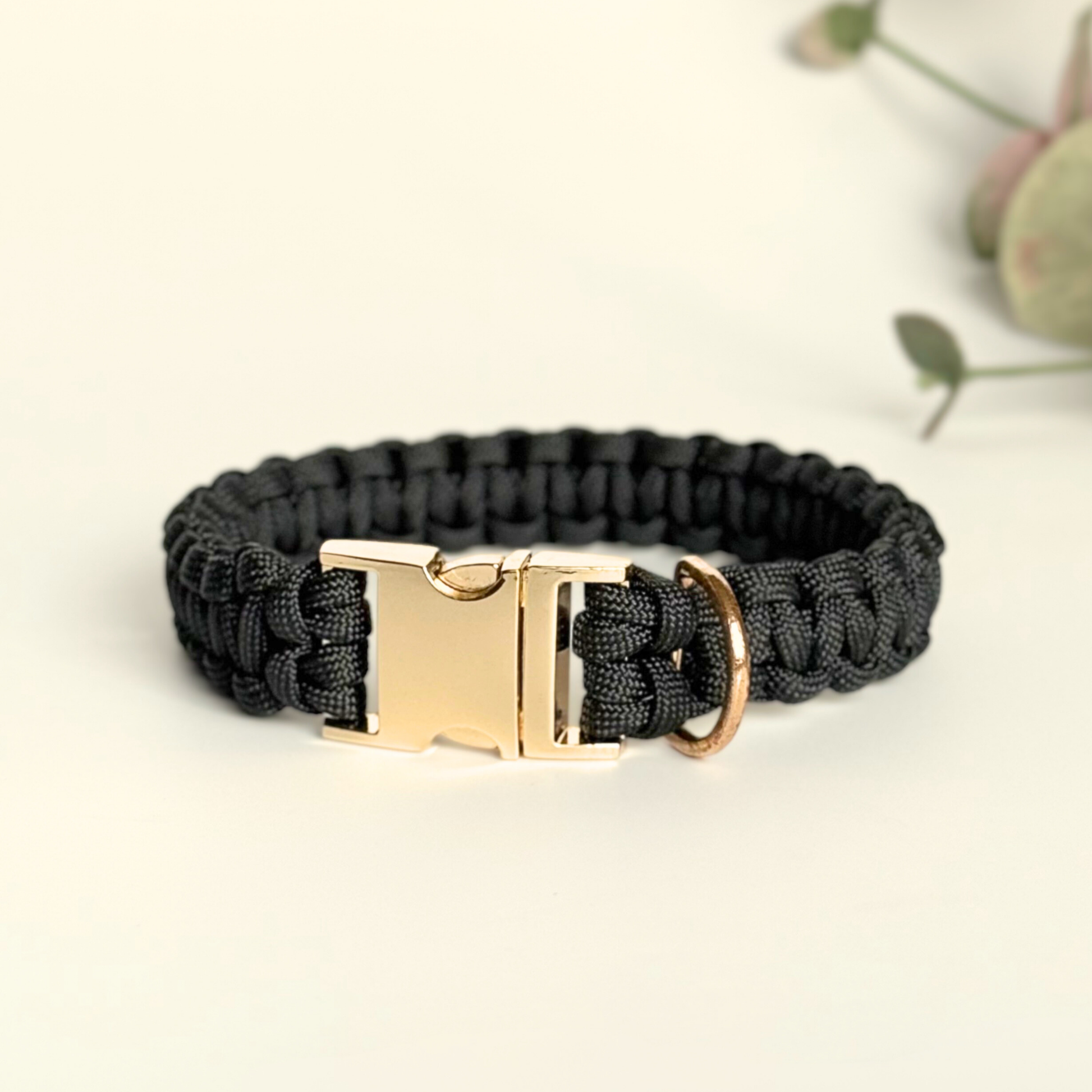Custom made black paracord dog collar shown with gold metal buckle option.