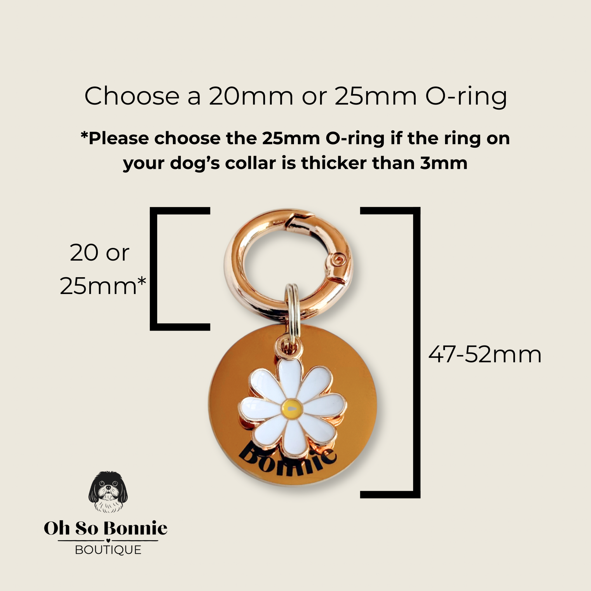 Gold white daisy flower dog collar ID tag, Enamel floral charm with dog name and address details. easily clips onto collar or harness. Pictured being held against a cream background.