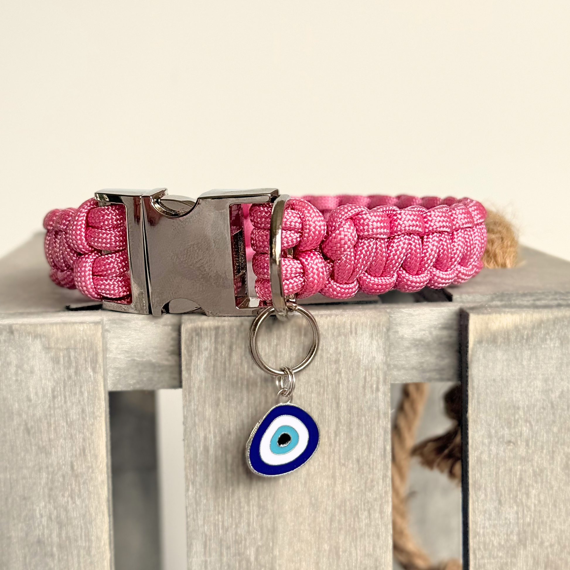 Silver plated blue turkish evil eye dog collar charm, for protection, security and grounding, 35mm easy to attach to pet collars. Picture shows the tag attached to a pink paracord dog collar.