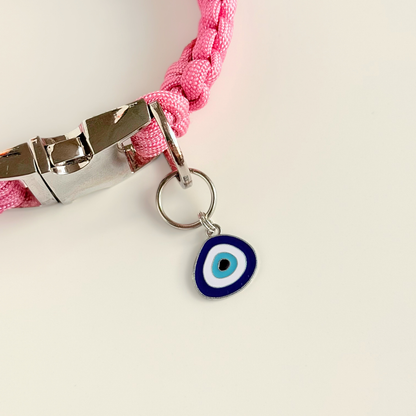 Silver plated blue turkish evil eye dog collar charm, for protection, security and grounding, 35mm easy to attach to pet collars. Picture shows the tag attached to a pink paracord dog collar.