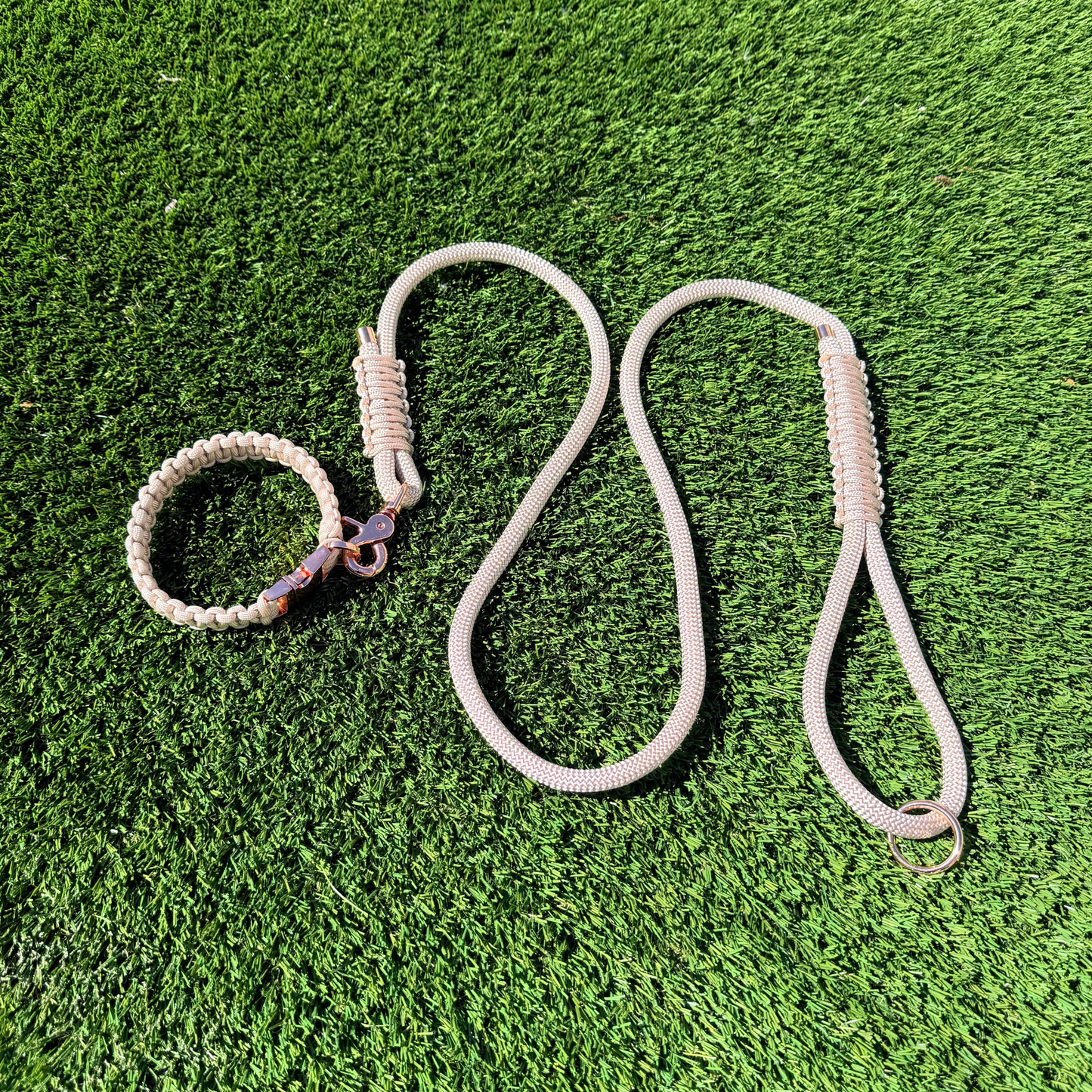 Custom made beige nylon rope dog collar set with matching paracord braided dog collar. Picture shows rose gold hardware option on a lawn