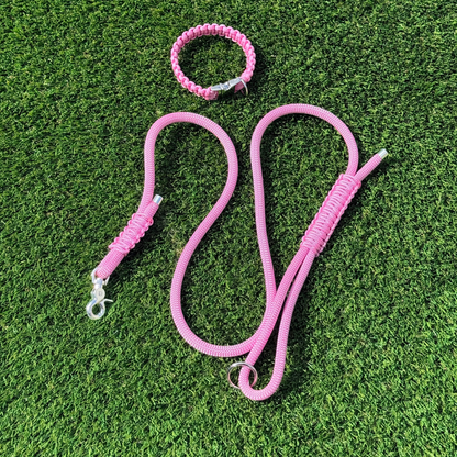 Custom made pink nylon rope dog collar set with matching paracord braided dog collar. Picture showing full set from above, on the lawn.