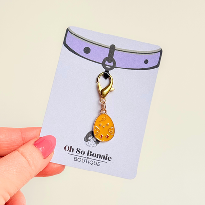Yellow chick Easter egg enamel dog collar charm that easily attaches to collars and harnesses with a gold plated lobster clasp. Pictured on the display card.