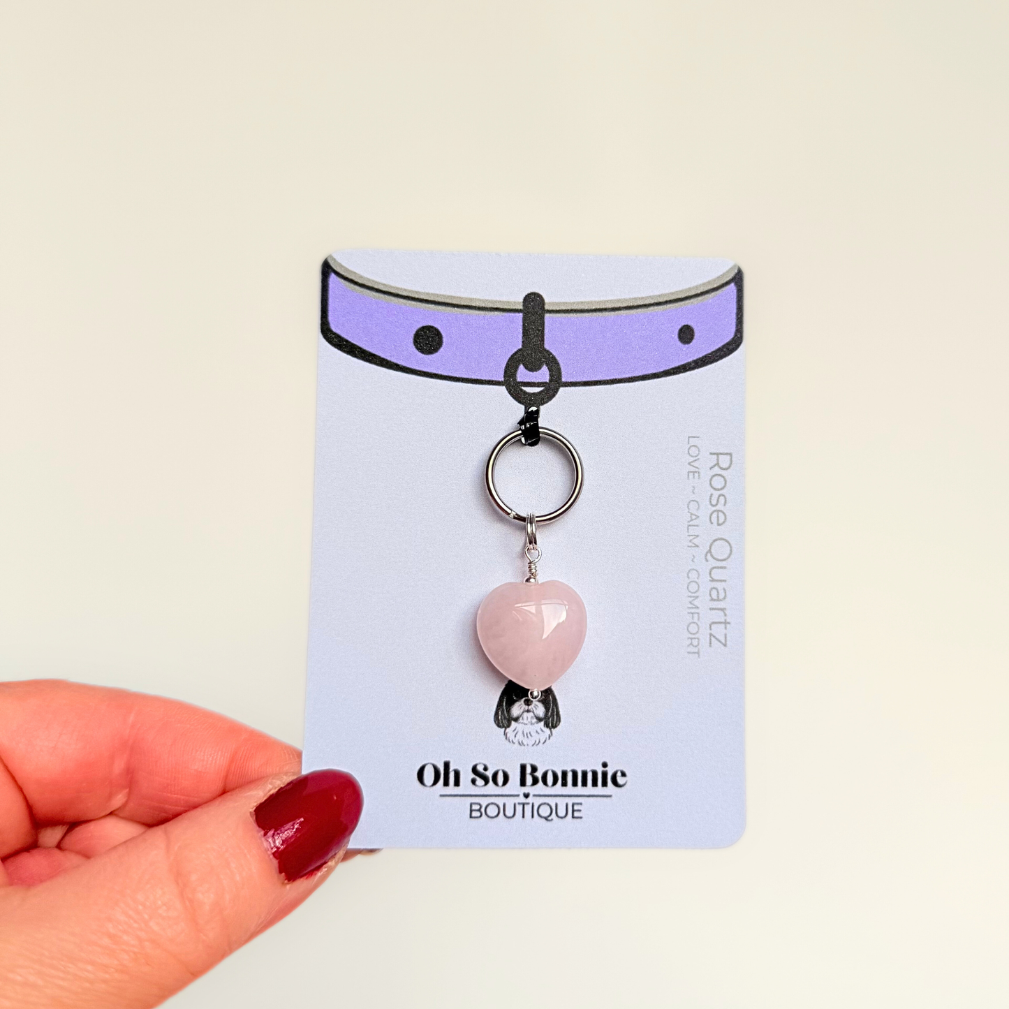 Handmade dog collar charm featuring a 15mm pink rose quartz natural gemstone crystal bead. Hung on a silver plated brass split ring that attaches onto your pet collar. Rose quartz can help pets with love, comfort and calming. Pictured on the display card.