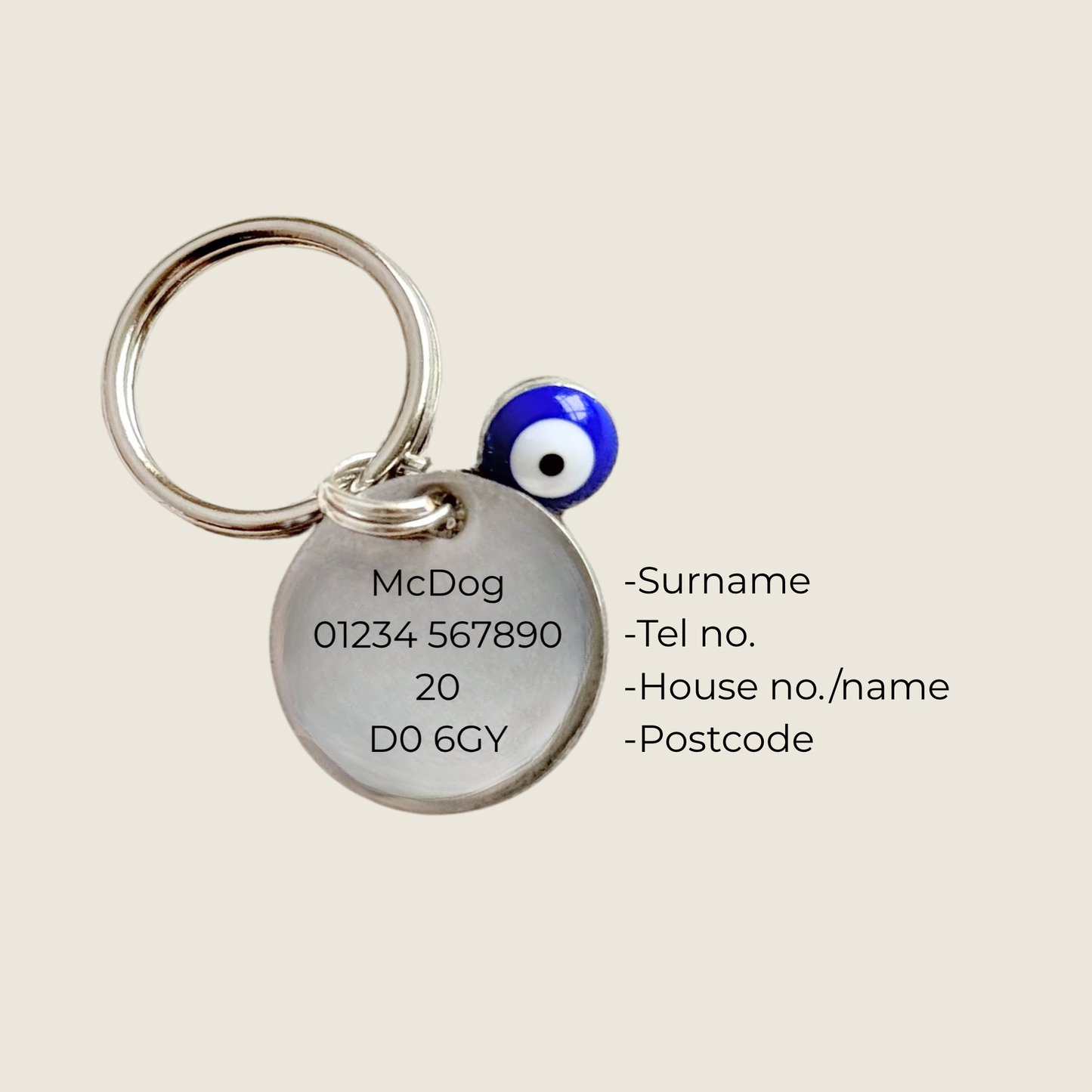 Silver plated brass and stainless steel 15mm dog collar charm with ID tag. Personalised custom identification tag with a small, blue Turkish Evil Eye charm, on a 15mm silver split ring. Engraved with the words ‘Good vibes only’ on the front. Pictured showing the personalisation on the back.