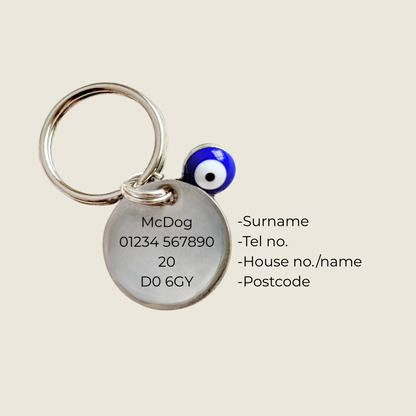Silver plated brass and stainless steel 15mm dog collar charm with ID tag. Personalised custom identification tag with a small, blue Turkish Evil Eye charm, on a 15mm silver split ring. Engraved with the words ‘Good vibes only’ on the front. Pictured showing the personalisation on the back.