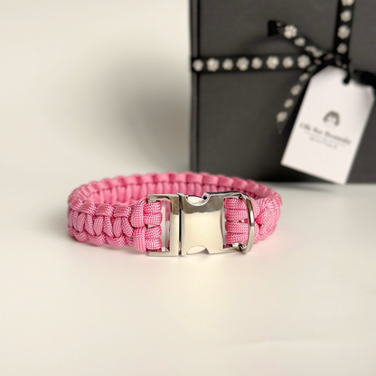‘Lavender pink’ handmade paracord dog collar with silver coloured buckle clasp. Custom made to your required size. Braided macrame style pet neckwear. Pictured in front of the gift box.