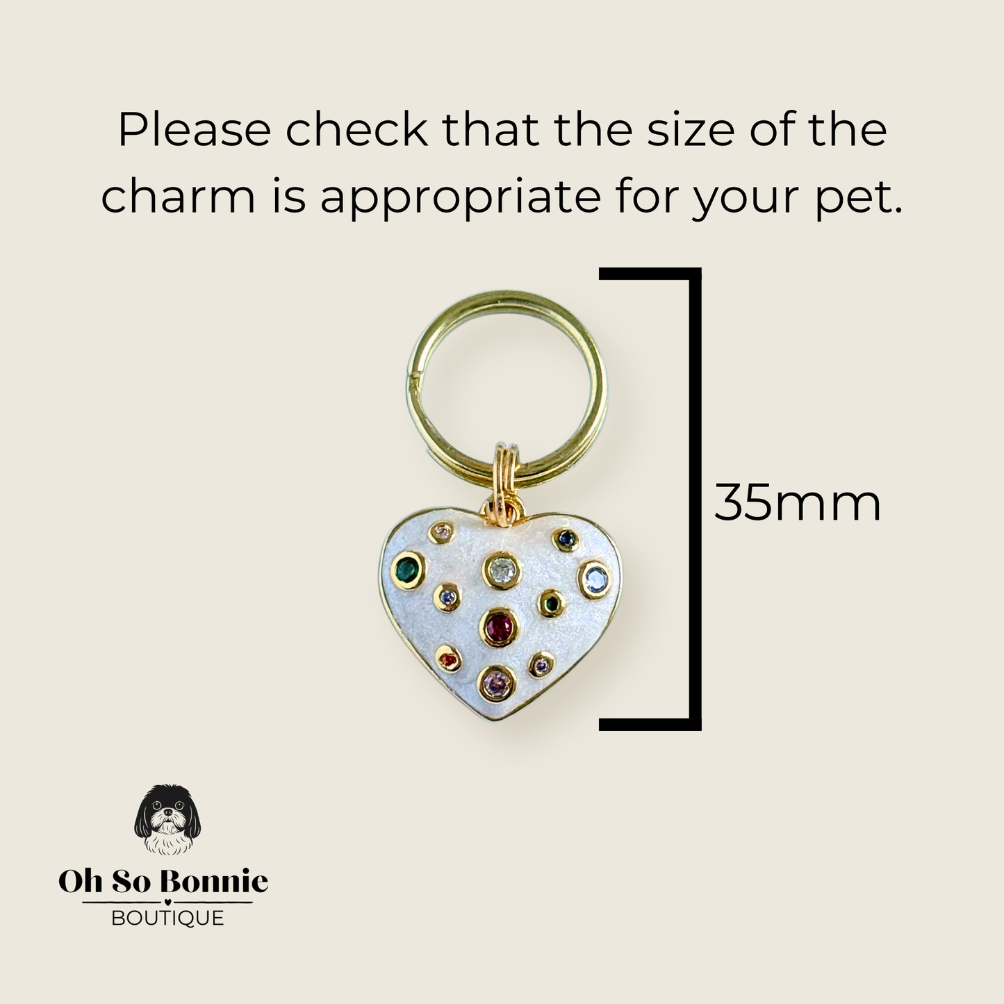 Heart shaped cream / off white pearlescent coloured enamel and brass pet collar charm featuring a selection of multicoloured cubic zirconia stones. Pictured against a cream background showing the dimensions of the charm.