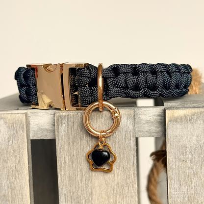 Crystal for dogs pet collar charm featuring a 10mm black onyx heart shaped bead and a brass gold coloured paw print tag. A stone for protection, strength and stability. Pictured attached to a black paracord collar